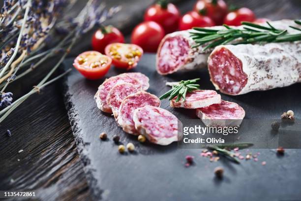 slices of fuet salami with baguette - salami stock pictures, royalty-free photos & images