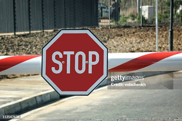 security entry with big red stop sign on the beam - open sign stockfoto's en -beelden