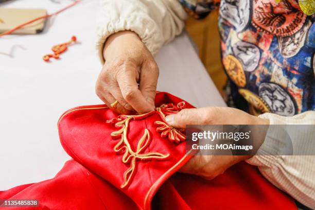 a tailor is sewing a chinese dress - embroidery stock pictures, royalty-free photos & images