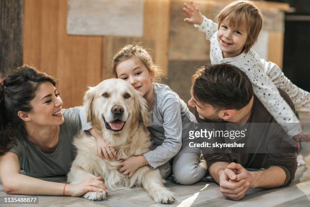 fröhliche familie entspannung mit ihrem retriever zu hause. - family dog stock-fotos und bilder