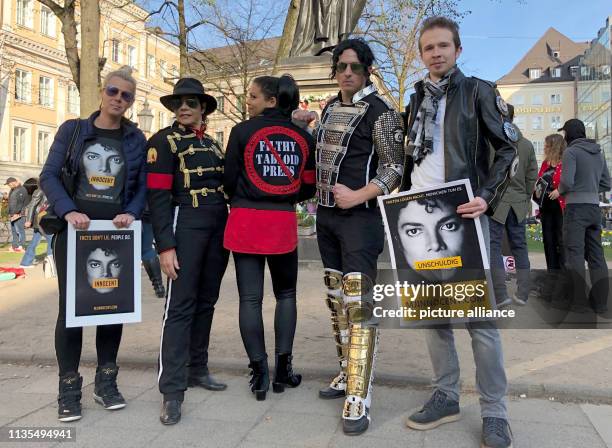 April 2019, Bavaria, München: Fans of the "King of Pop", Michael Jackson, and fans with posters with the inscription "Innocent" stand in front of the...