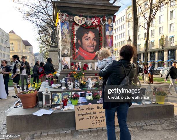 April 2019, Bavaria, München: A woman stands in front of the monument to Orlando-di-Lasso, a composer and conductor of the Renaissance, who was...