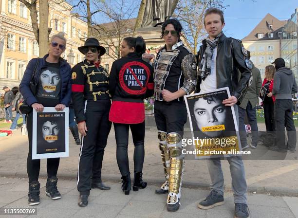 April 2019, Bavaria, München: Fans of the "King of Pop", Michael Jackson, and fans with posters with the inscription "Innocent" stand in front of the...