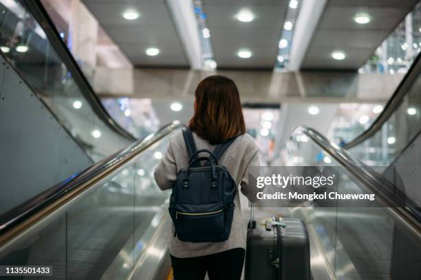 young woman holding suitcase or baggage with backpack in the international airport. - airport terminal interior fotografías e imágenes de stock