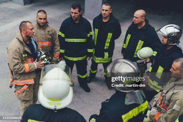 équipe de pompiers écoutant les instructions - par équipe photos et images de collection