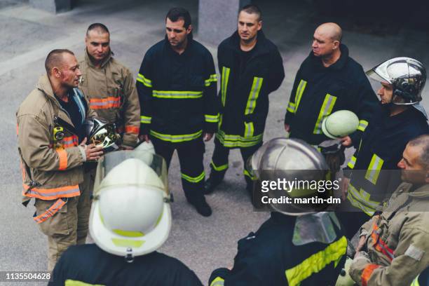 team of firefighters listening to instructions - accidents and disasters stock pictures, royalty-free photos & images