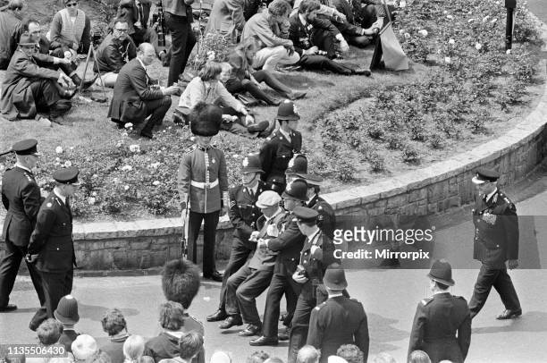 The Investiture of Prince Charles at Caernarfon Castle, Pictured, policemen drag away a man from the crowd in Castle Square, Caernarfon, Wales, 1st...