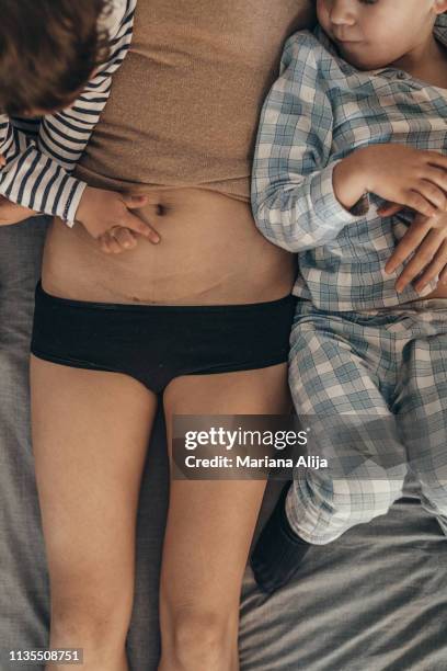 mother showing csection scar to her children - birth of prophet mohammed is marked in kashmir stockfoto's en -beelden