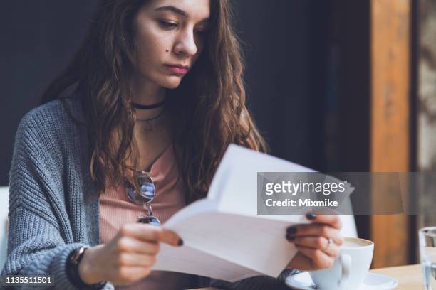beautiful woman reading paper documents - reading letter stock pictures, royalty-free photos & images
