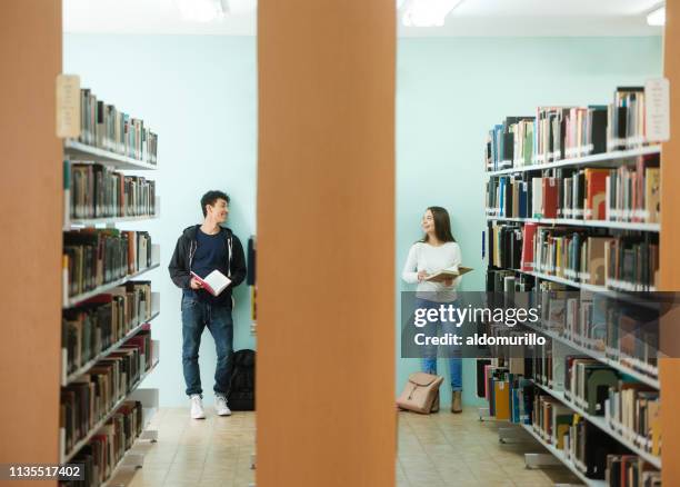 freunde, die in der bibliothek sprechen - two men studying library stock-fotos und bilder
