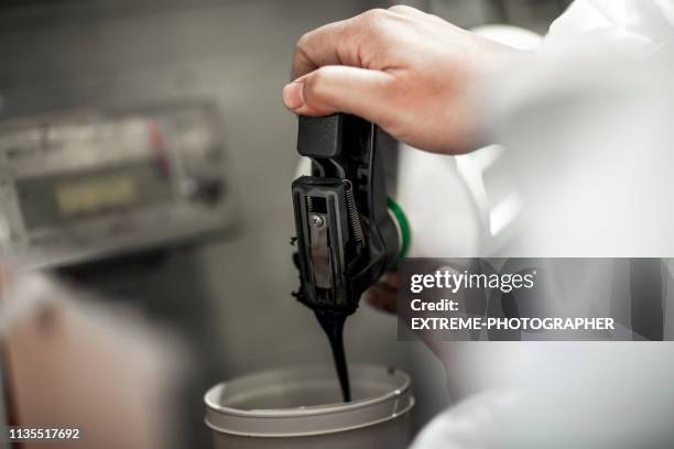 car colorist pouring and preparing paint in a spraying container - mixing stock pictures, royalty-free photos & images