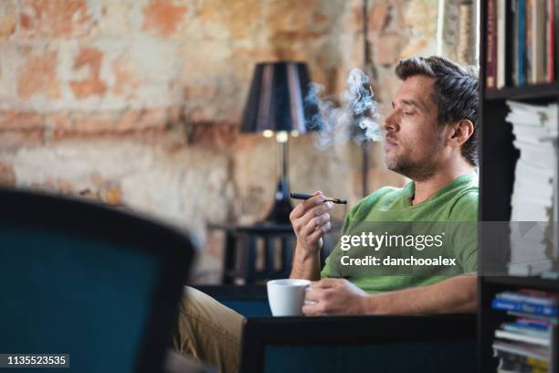 young man using electronic cigarette - vaping danger stock pictures, royalty-free photos & images