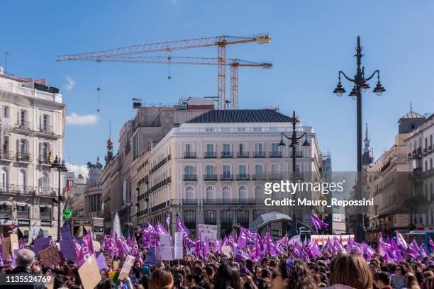 a crowd of people, most of them women wearing purple stuff during the international womens day at puerta del sol in madrid city, spain. - international womens day around the world stock pictures, royalty-free photos & images
