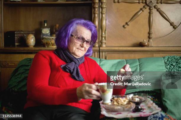 attractive elderly woman with cup of coffee - senior colored hair stock pictures, royalty-free photos & images