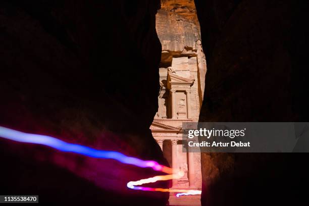 the al khazneh treasury tomb at night from canyon with colorful light trail. - the siq fotografías e imágenes de stock