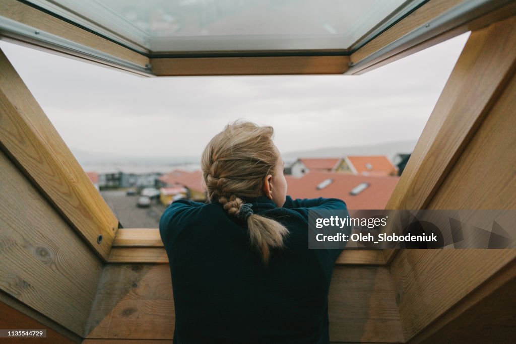Frau schaut auf das Fenster auf die Stadt