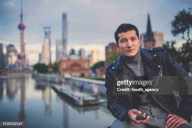 man sitting by the river and texting - youth water polo stock pictures, royalty-free photos & images
