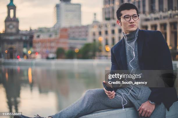 man sitting by the river and texting - youth water polo stock pictures, royalty-free photos & images