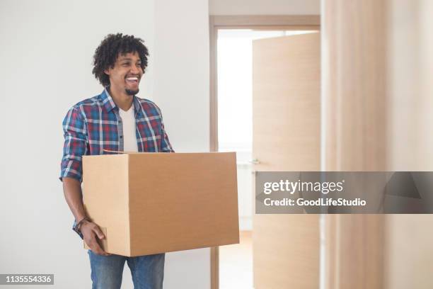 young man carrying a box - carrying box stock pictures, royalty-free photos & images