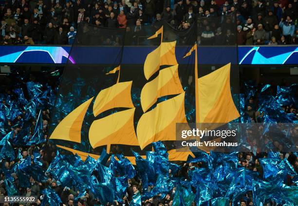 Banner featuring the ship from the Manchester City club crest is held by fans before the UEFA Champions League Round of 16 Second Leg match between...