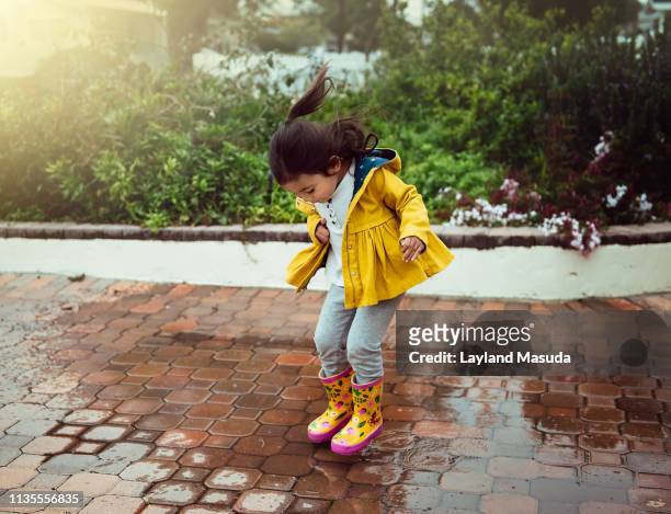puddle jumping toddler girl - puddles stock pictures, royalty-free photos & images