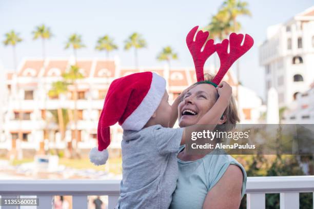 grandmother and grandson celebrating christmas in tropical holidays - summer christmas stock pictures, royalty-free photos & images