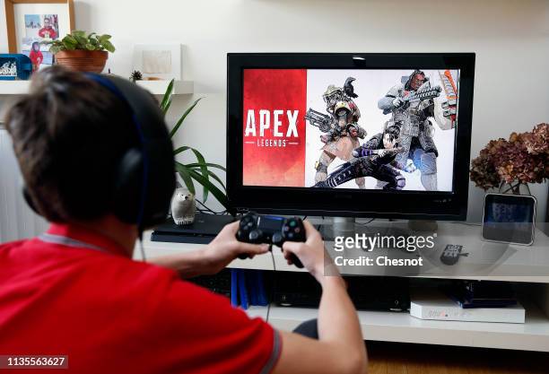 In this photo illustration a teenager plays the video game Apex Legends developed by Respawn Entertainment and published by Electronic Arts on a Sony...
