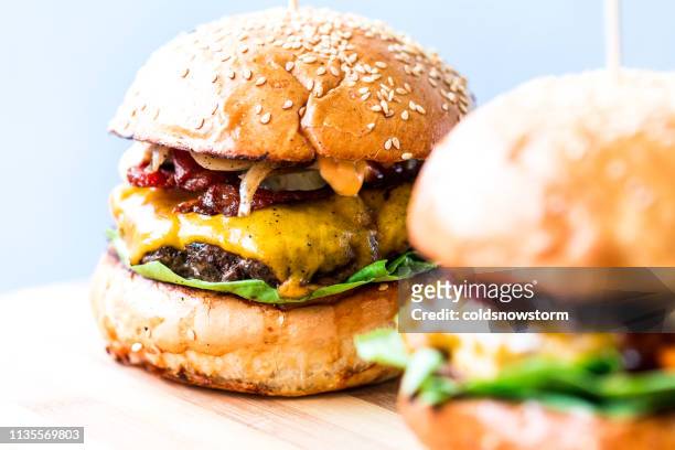 hamburgers au fromage de bacon grillés fraîchement enflammé en rangée - burger on grill photos et images de collection