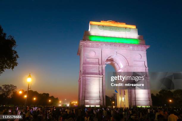 image of all india war memorial / new delhi india gate night time view with crowds of tourists, illuminated gateway arch - india gate stock pictures, royalty-free photos & images