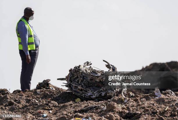Investigators and recovery workers inspect a second engine after it is recovered from a crater at scene of the Ethiopian Airlines Flight 302 crash on...