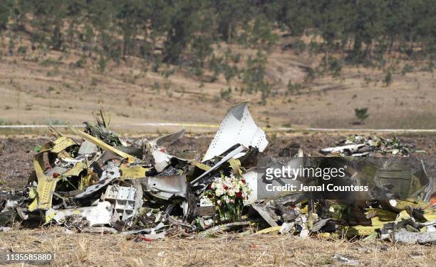 Bouquet of flowers is placed in front of a pile of debris at the scene of the Ethiopian Airlines Flight 302 crash on March 13, 2019 in Ejere,...