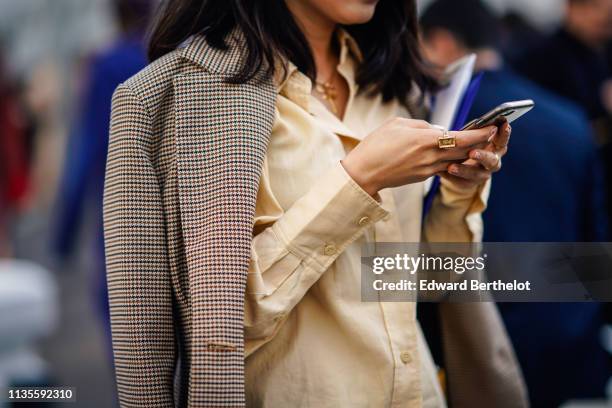 Guest wears a light brown houndstooth jacket, an ecru shirt, outside Chloe, during Paris Fashion Week Womenswear Fall/Winter 2019/2020, on February...