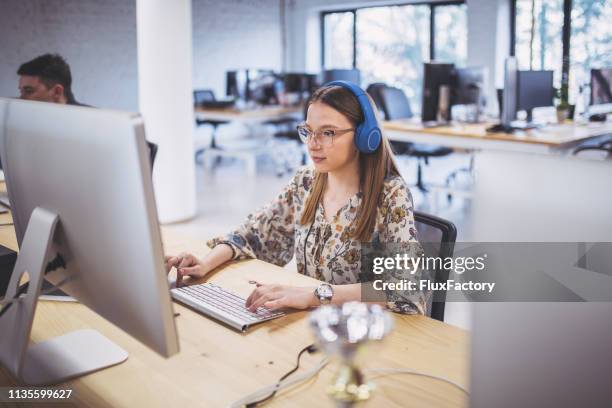 lovely female programmer working with colleagues at the office - programmer working stock pictures, royalty-free photos & images