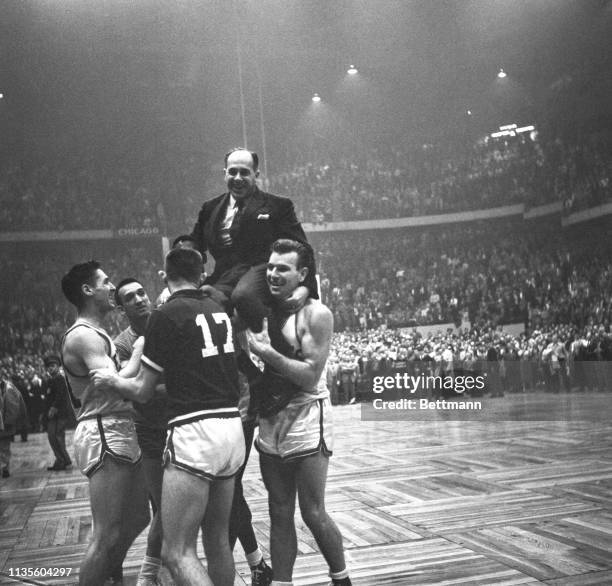 Happy Celtics players hoist their coach, Red Auerbach, to their shoulders after downing the Syracuse Nationals, 83-80, making it three straight over...