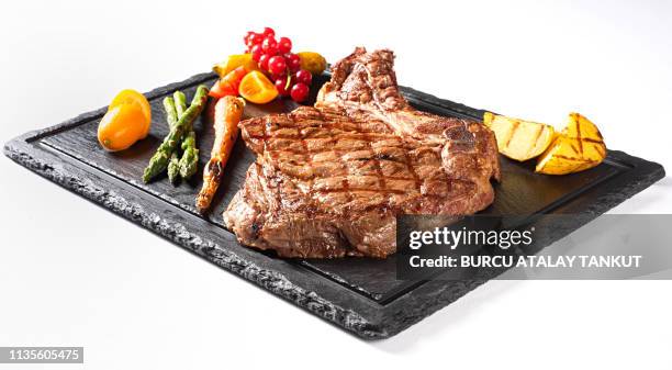 grilled steak served on stone - rippensteak stock-fotos und bilder