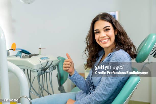 young beautiful woman after successful dental treatment - dentist's chair stock pictures, royalty-free photos & images