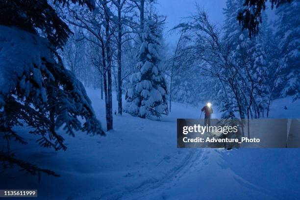 backcountry ski touring at dusk with fresh snow and headlamp - night skiing stock pictures, royalty-free photos & images