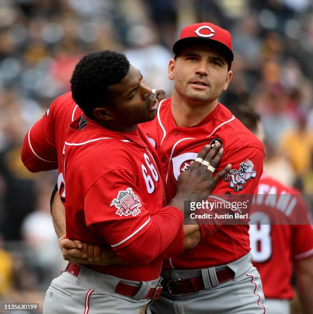 Yasiel Puig of the Cincinnati Reds is restrained by Joey Votto after benches clear in the fourth inning during the game against the Pittsburgh...