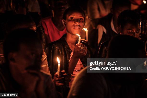 Woman holds a candle during a night vigil and prayer at the Amahoro Stadium as part of the 25th Commemoration of the 1994 Genocide, in Kigali,...