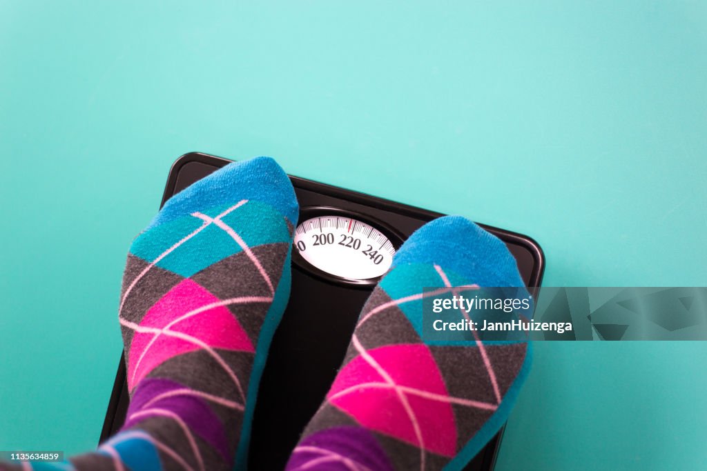Overweight: Feet in Colorful Argyle Socks on Scale