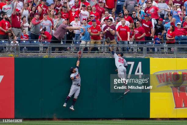 Eddie Rosario and Byron Buxton of the Minnesota Twins leap but cannot catch the two run home run ball hit by Rhys Hoskins of the Philadelphia...