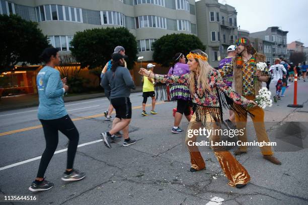 Volunteers hand out flowers to runners during the United Airlines Rock 'N' Roll Half Marathon San Francisco on April 7, 2019 in San Francisco,...