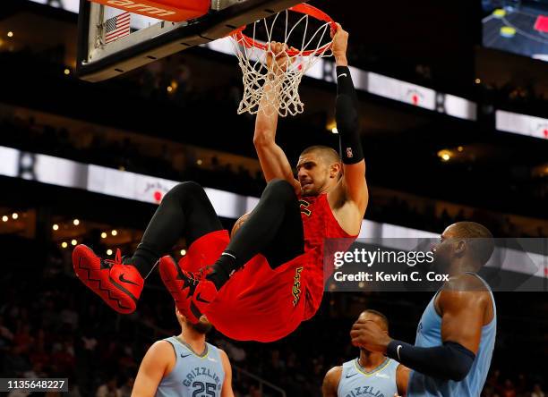 Alex Len of the Atlanta Hawks dunks against CJ Miles of the Memphis Grizzlies in th second half at State Farm Arena on March 13, 2019 in Atlanta,...