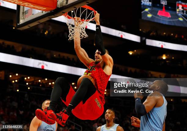 Alex Len of the Atlanta Hawks dunks against CJ Miles of the Memphis Grizzlies in th second half at State Farm Arena on March 13, 2019 in Atlanta,...