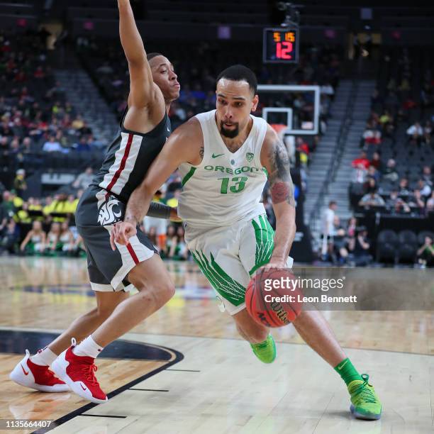 Oregon Ducks forward Paul White handles the ball against Washington State Cougars guard Jervae Robinson during a first-round game of the Pac-12...