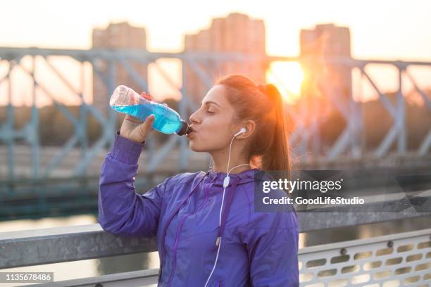 junge frau trinkt vitaminwasser - energydrink stock-fotos und bilder