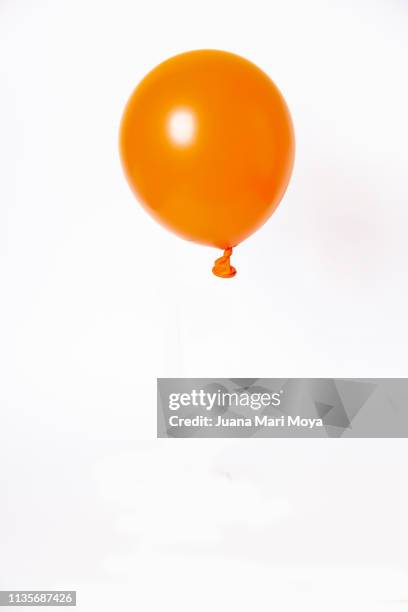 orange balloon, floating on white background - ballon de baudruche photos et images de collection
