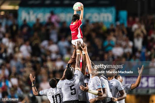 The Fiji Rugby Team holds a ball boy while praying during the day three of the Cathay Pacific/HSBC Hong Kong Sevens Cup Final match between Fiji and...