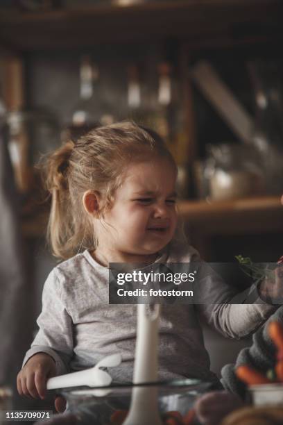 baby girl frowning after she tried radishes - crying toddler stock pictures, royalty-free photos & images