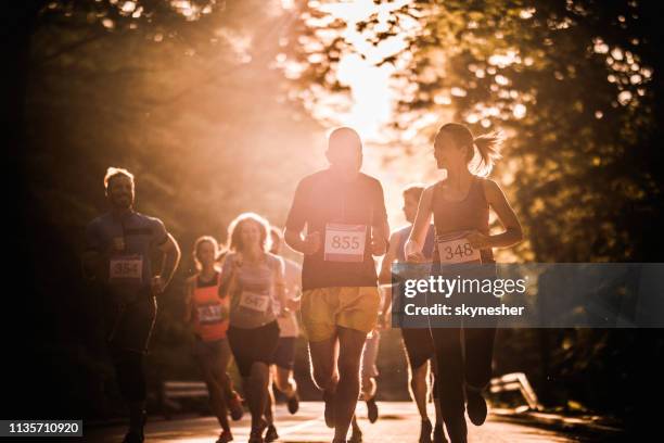 grote groep van atletische mensen lopen marathon race in de natuur bij zonsondergang. - 10000 meter stockfoto's en -beelden